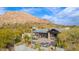 Aerial view of a home with a pool and patio, showcasing its desert mountain setting at 7002 E Leisure Ln, Carefree, AZ 85377