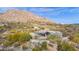 Aerial view of a luxurious home nestled in a mountainside community with a pool and desert landscaping at 7002 E Leisure Ln, Carefree, AZ 85377