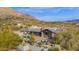 Aerial view of a luxurious home with a pool and patio, nestled in a desert mountain setting at 7002 E Leisure Ln, Carefree, AZ 85377