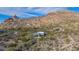 Aerial view showcasing a home's unique desert setting, nestled amongst mountains and desert flora at 7002 E Leisure Ln, Carefree, AZ 85377