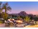 Desert landscaping with firepit and seating area, mountain views at sunset at 7002 E Leisure Ln, Carefree, AZ 85377