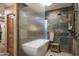 Spa-like bathroom with walk-in shower, soaking tub, and stone tile at 7002 E Leisure Ln, Carefree, AZ 85377