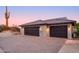 Home's exterior features a two-car garage and desert landscaping at 7002 E Leisure Ln, Carefree, AZ 85377