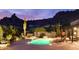 Night view of a kidney-shaped pool, surrounded by desert landscaping at 7002 E Leisure Ln, Carefree, AZ 85377