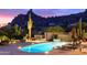 Night view of a kidney-shaped pool with lounge chairs and desert views at 7002 E Leisure Ln, Carefree, AZ 85377