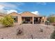 Landscaped backyard with covered patio and grill at 8047 W Cinder Brook Way, Florence, AZ 85132