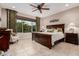 Large bedroom with king-size bed, ceiling fan, and plenty of natural light at 8047 W Cinder Brook Way, Florence, AZ 85132