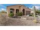 House exterior showcasing a tan stucco finish, desert landscaping, and a two-car garage at 8047 W Cinder Brook Way, Florence, AZ 85132