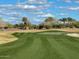 Golf course with palm trees and a putting green under a partly cloudy sky at 8047 W Cinder Brook Way, Florence, AZ 85132