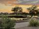 Scenic sunset view of a golf course with a pond and walking path at 8047 W Cinder Brook Way, Florence, AZ 85132