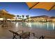 Inviting pool area with lounge chairs and umbrellas at sunset at 8047 W Cinder Brook Way, Florence, AZ 85132