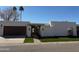 Contemporary single-story home featuring a two-car garage, manicured lawn, and desert landscaping at 8165 E Del Cuarzo Dr, Scottsdale, AZ 85258