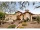 Desert landscaping surrounds this single-story home with stucco exterior and inviting entryway at 8255 E Vista De Valle --, Scottsdale, AZ 85255