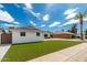 White brick home with a two car garage and lush green lawn at 8631 E Jackrabbit Rd, Scottsdale, AZ 85250