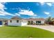 White brick home with a two car garage and lush green lawn at 8631 E Jackrabbit Rd, Scottsdale, AZ 85250