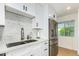 Modern kitchen with white cabinets, quartz countertops, and a double sink at 8631 E Jackrabbit Rd, Scottsdale, AZ 85250