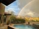 Stunning pool area with a breathtaking rainbow and mountain backdrop at 8787 E Lost Gold Cir, Gold Canyon, AZ 85118