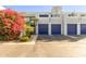 Condo exterior featuring a walkway, attached garages, and vibrant landscaping at 902 W Glendale Ave # 203, Phoenix, AZ 85021