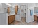 Bathroom with double sinks, wood cabinets, and a walk-in closet at 9758 E Meseto Ave, Mesa, AZ 85209