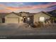 Tan house with tile roof, two-car garage, and desert landscaping at 9758 E Meseto Ave, Mesa, AZ 85209