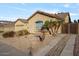 Tan house with tile roof, two-car garage, and desert landscaping at 9758 E Meseto Ave, Mesa, AZ 85209