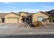 Tan house with tile roof, two-car garage, and desert landscaping at 9758 E Meseto Ave, Mesa, AZ 85209