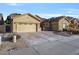 Tan house exterior with a two-car garage and landscaping at 9758 E Meseto Ave, Mesa, AZ 85209