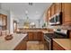 Kitchen with wood cabinets, an island, and stainless steel appliances at 9758 E Meseto Ave, Mesa, AZ 85209