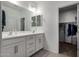 Double vanity bathroom with a large mirror and adjacent closet at 17244 W Lynx Rd, Goodyear, AZ 85338