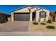 One-story home with dark brown garage door, landscaping, and a brick driveway at 17244 W Lynx Rd, Goodyear, AZ 85338