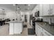 Open kitchen with island, white cabinets, and stainless steel appliances at 17244 W Lynx Rd, Goodyear, AZ 85338