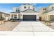 Two-story house with a dark gray garage door and landscaping at 17631 W Sanna St, Waddell, AZ 85355