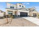 Two-story house with a dark gray garage door and landscaping at 17631 W Sanna St, Waddell, AZ 85355