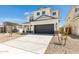 Two-story house with a dark gray garage door and landscaping at 17631 W Sanna St, Waddell, AZ 85355