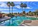 Inviting community pool with palm trees and a waterfall feature at 18064 W Buena Vista Dr, Surprise, AZ 85374
