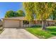 Brick ranch house with a large weeping willow tree and well-manicured lawn at 18202 N 99Th Dr, Sun City, AZ 85373