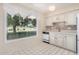 Kitchen features white cabinets and a large window overlooking the golf course at 18202 N 99Th Dr, Sun City, AZ 85373