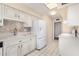 White kitchen with stainless steel appliances and view to backyard at 18202 N 99Th Dr, Sun City, AZ 85373