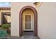 Front entrance with arched entryway and wrought iron security door at 19241 N Emerald Cove Way, Surprise, AZ 85387