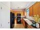View of kitchen with wood cabinets, black appliances, and tile flooring at 19241 N Emerald Cove Way, Surprise, AZ 85387