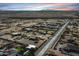 Community aerial view of a charming neighborhood near the desert and mountains under a vibrant sunset at 20232 W Mazatzal Dr, Wittmann, AZ 85361