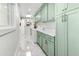 Bright laundry room with light green cabinets, white countertops, and tile floor at 4712 E Palo Verde Dr, Phoenix, AZ 85018