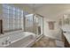 Relaxing bathroom with soaking tub, shower, and large window at 6623 W Robin Ln, Glendale, AZ 85310
