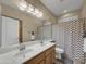 Bathroom with double sinks and a zig-zag patterned shower curtain at 6623 W Robin Ln, Glendale, AZ 85310