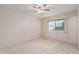 Spacious bedroom with ceiling fan, carpet flooring, and large window at 10407 W Desert Forest Cir, Sun City, AZ 85351