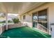 Covered patio with green carpet and sliding glass door at 10407 W Desert Forest Cir, Sun City, AZ 85351