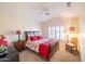 Bright bedroom with a queen-size bed and ceiling fan at 14309 W Rico Dr, Sun City West, AZ 85375