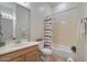 Bathroom with shower/tub combo, wood vanity, and mirror at 14848 W Edgemont Ave, Goodyear, AZ 85395