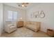 Well-lit Bedroom featuring a crib, chair, and decor at 14848 W Edgemont Ave, Goodyear, AZ 85395