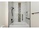 Updated bathroom with a bathtub shower, new tile and grab bars at 15920 W Summerwalk Dr, Surprise, AZ 85374